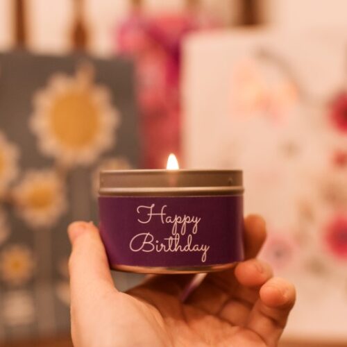 Happy birthday mini tin candle - held in hand