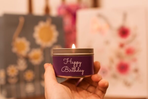 Happy birthday mini tin candle - held in hand